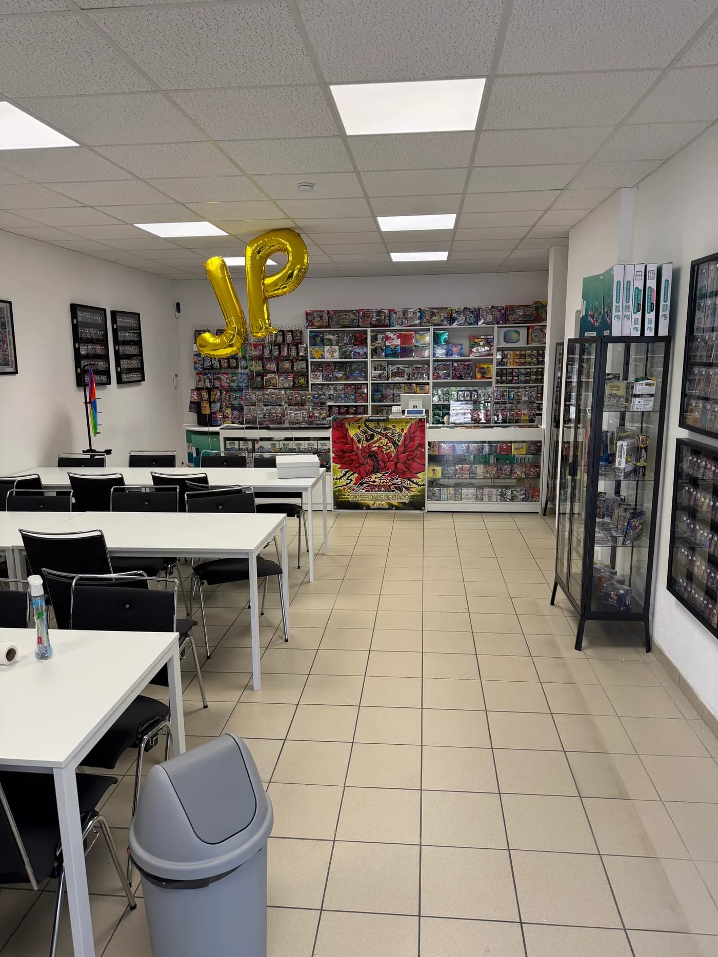 Blick durch das J-Productions Ladengeschäft mit Spieltischen, Vitrinen und Verkaufstresen